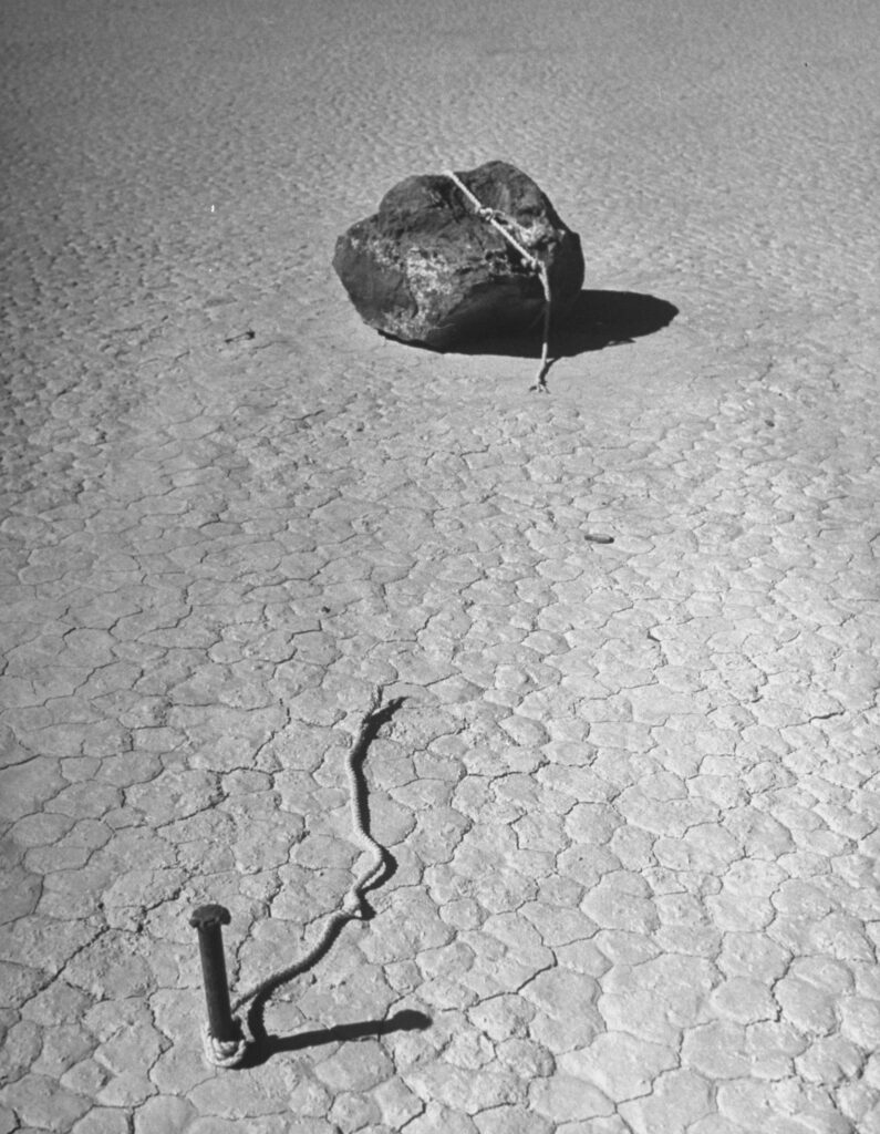 LIFE's 1952 story on the Racetrack Playa described this photo as being from a "ghost experiment," guessing that an amateur scientist had tied up the rock to keep it from moving, but over time the rope had eventually rotted away.